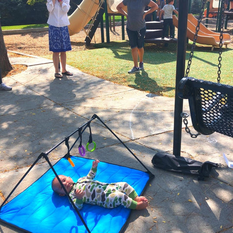 Baby at playground laying on blue Lay and Play Adventure  Mat