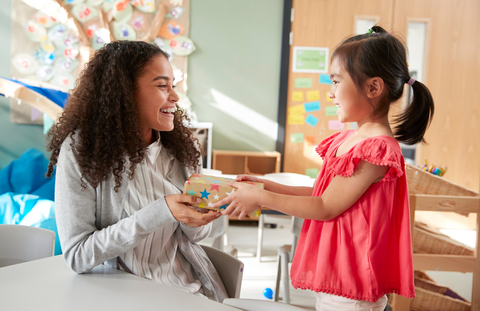 child giving a teacher a Christmas present