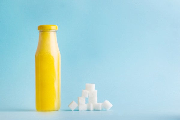 A glass jar for juice with sugar on a blue background