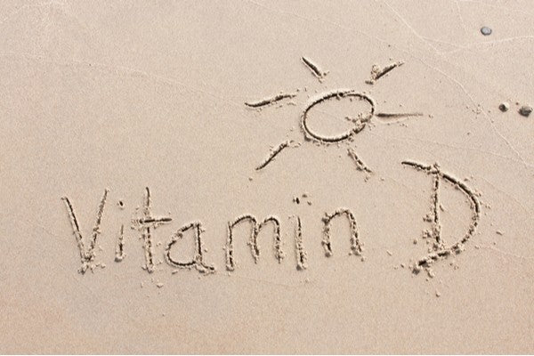 Vitamin D handwritten in sand beach