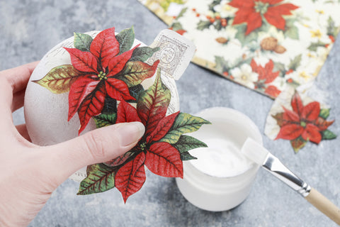 Wooden egg crafted with a red poinsettia themed decorative paper napkin.