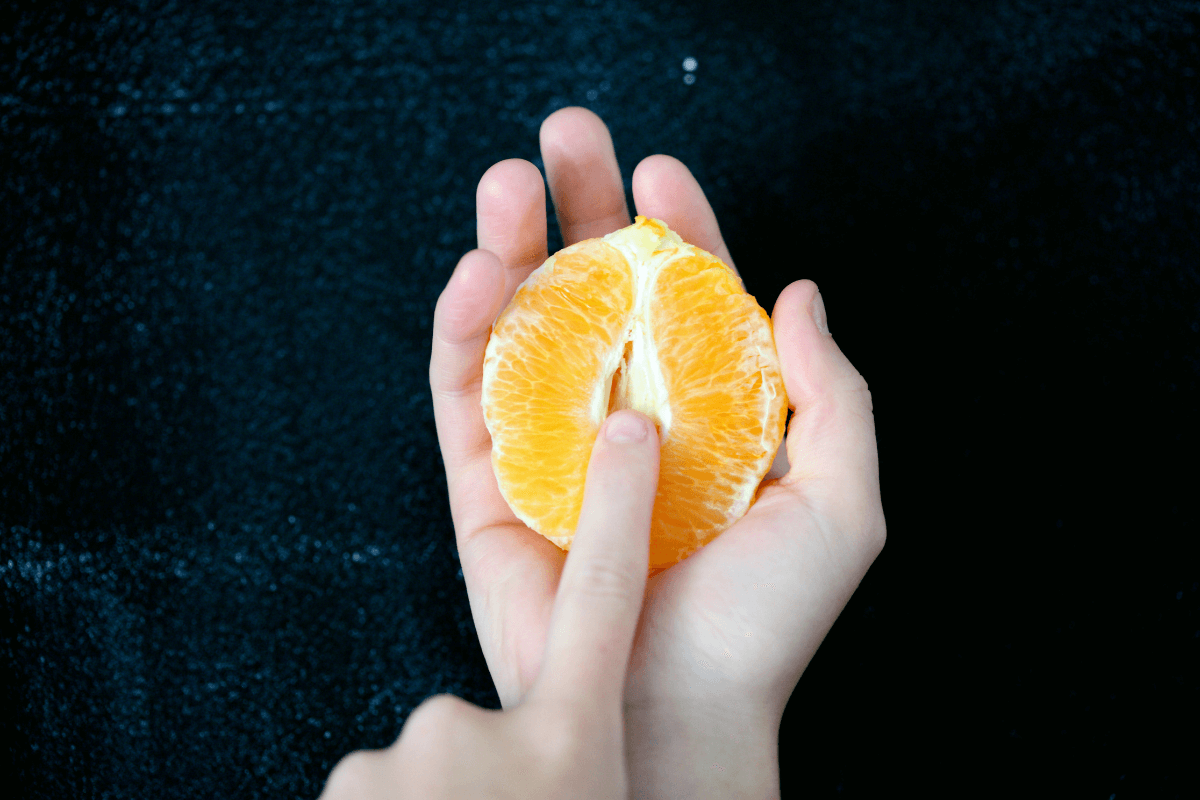 orange fruit with finger in