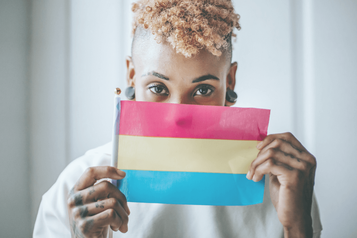 A woman holding up a pansexuality flag