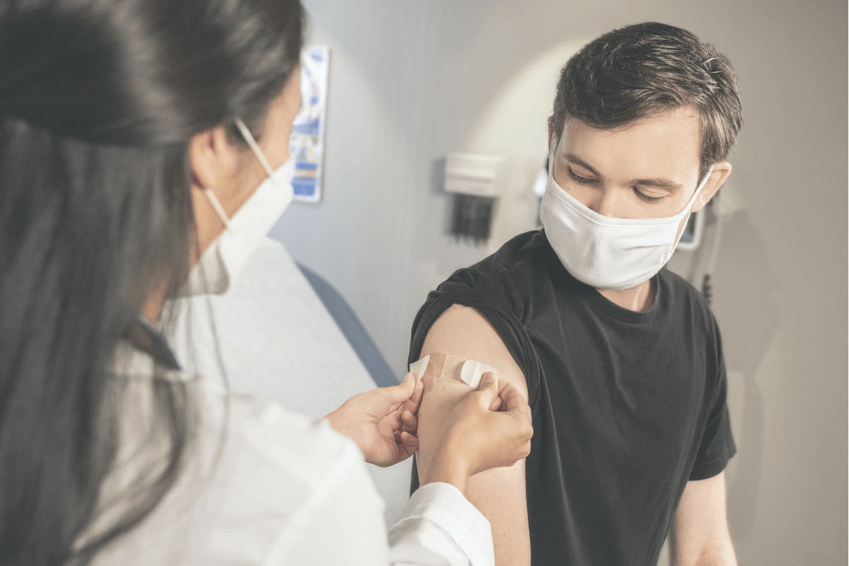 Female doctor putting band AID on a man's arm 