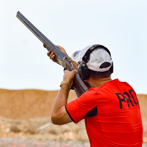 Hombre apuntando con la pistola en el aire mientras usa auriculares