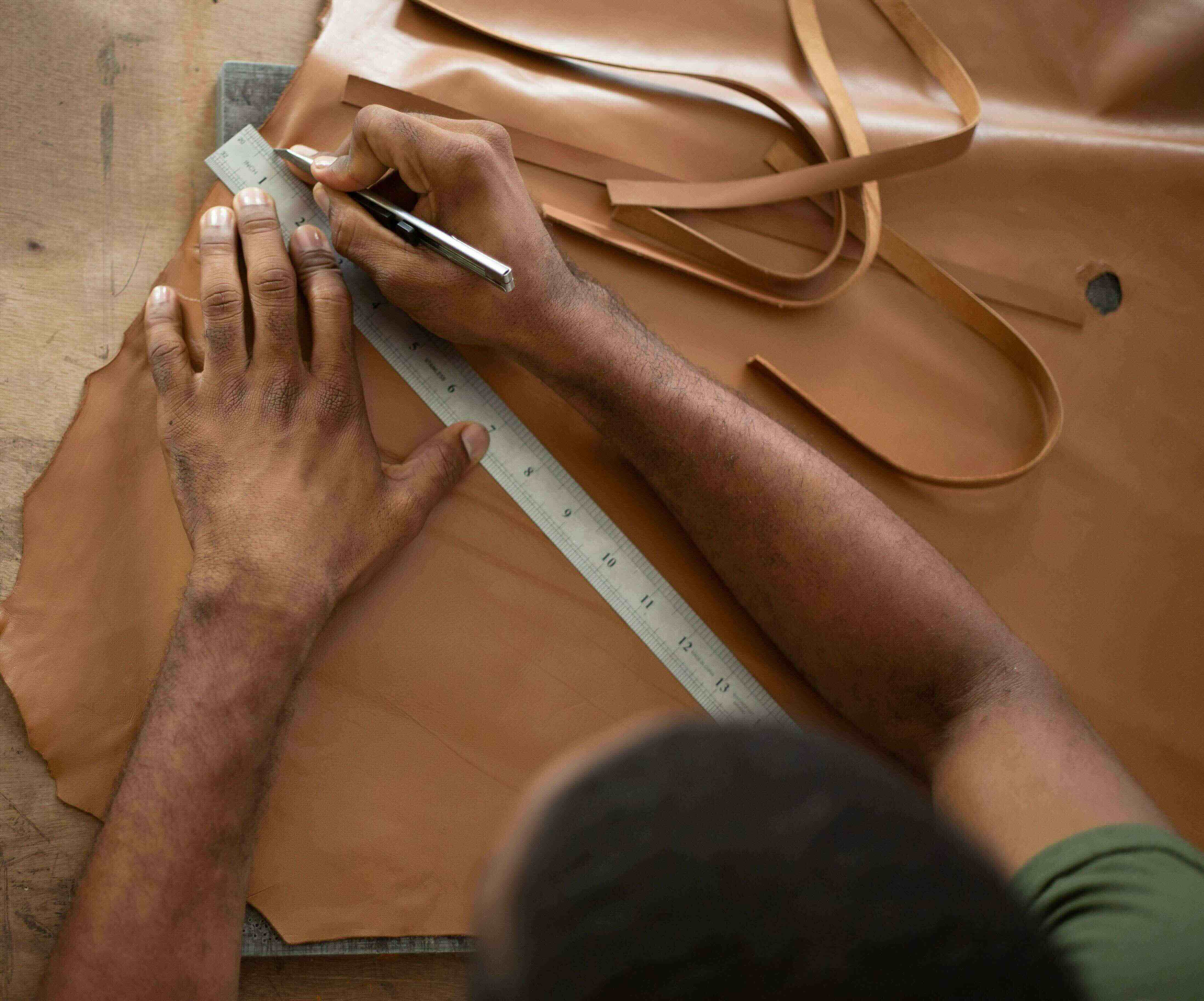 haitian-craftsman-making-leather-strips.jpeg__PID:3762d4fc-84dc-4a04-b14d-db7e77dc2aa1