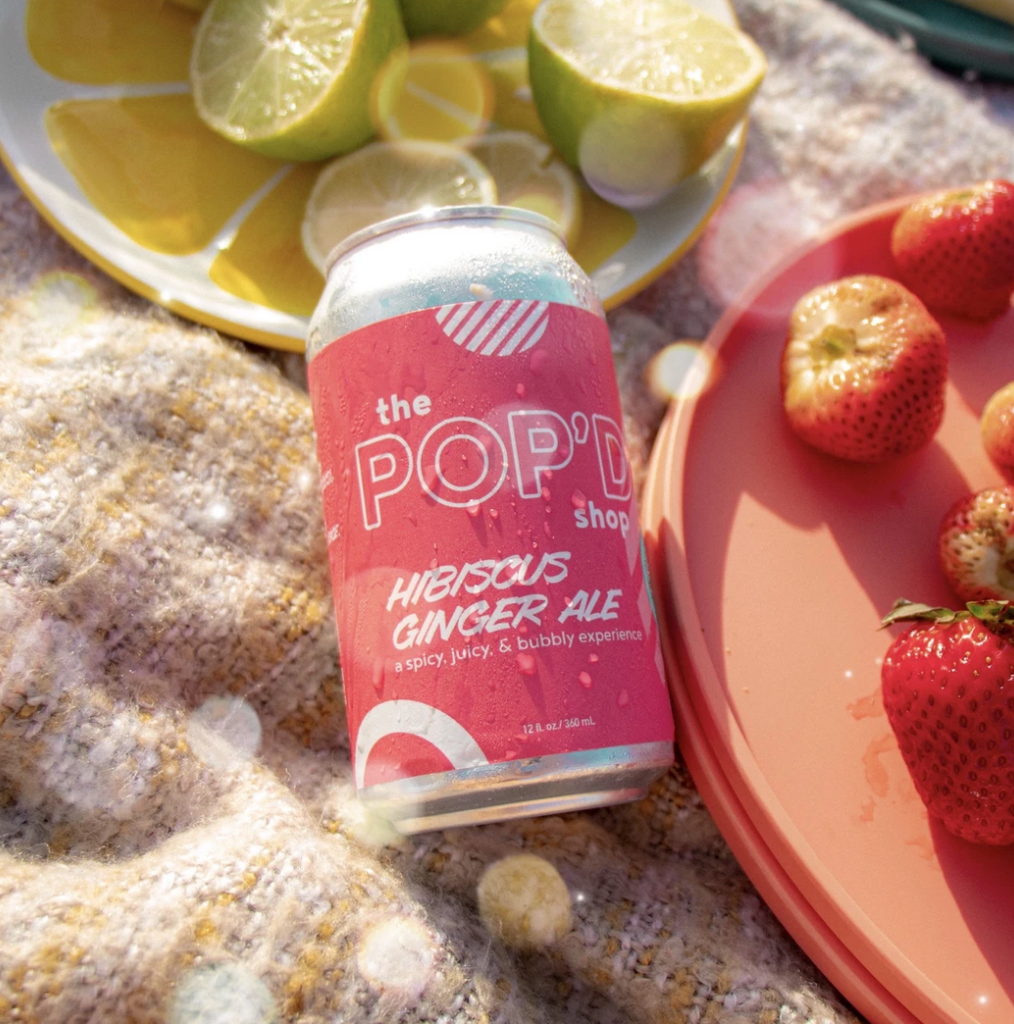 can of ginger ale soda, pink label, surrounded by lemons and strawberries