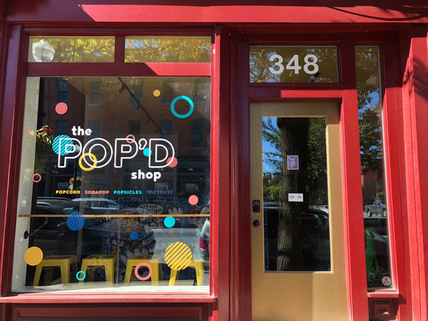 Colorful storefront in downtown Lancaster, Pennsylvania with the Pop'D shop logo on the window.