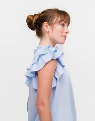 Pretty woman wearing a light blue designer flutter sleeve top