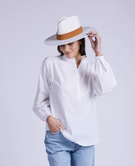Pretty woman wearing a designer tunic top with jeans and a hat