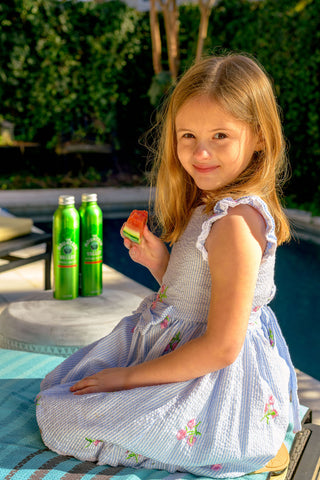 girl eating watermelon and drinking water at pool