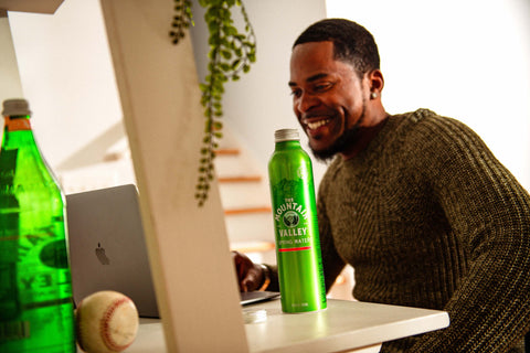 Man at computer smiling with Mountain Valley Water