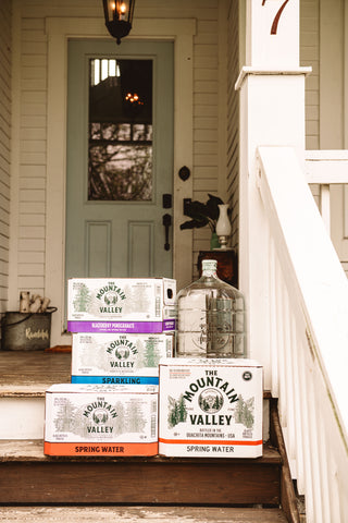 Boxes and jugs of Mountain Valley Spring Water on porch steps