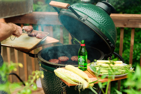 Big Green Egg grilling with burgers, corn and Mountain Valley