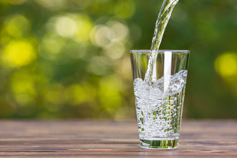 Water pouring into glass outdoors