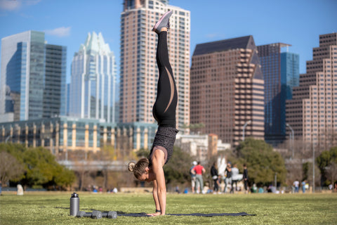 Woman doing a handstand with her water bottle in Austin, Texas