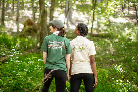 Two women wearing Mountain Valley shirts in the woods