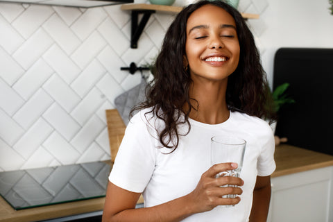 Woman drinking water and smiling