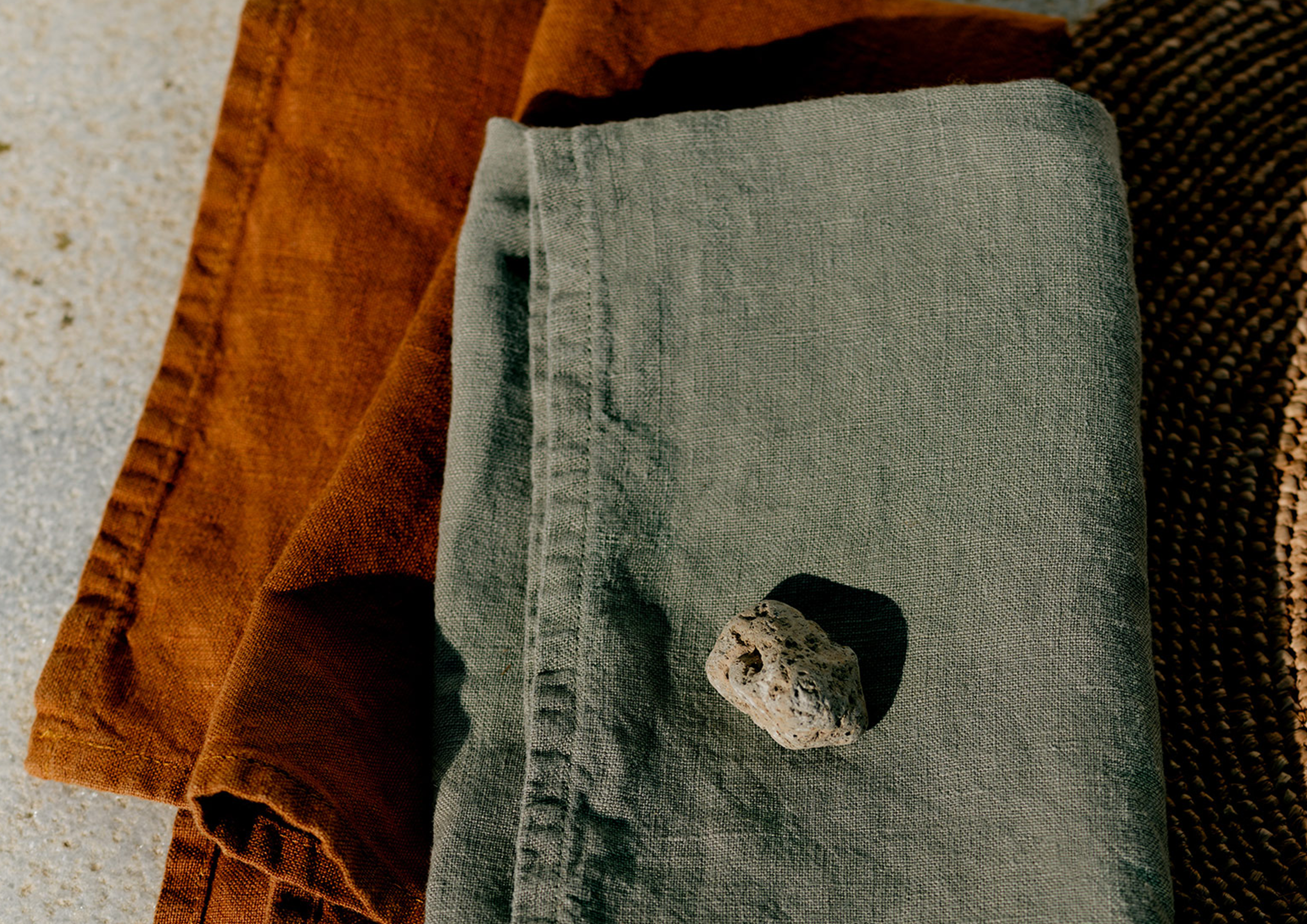 A green linen napkin and an orange linen napkin