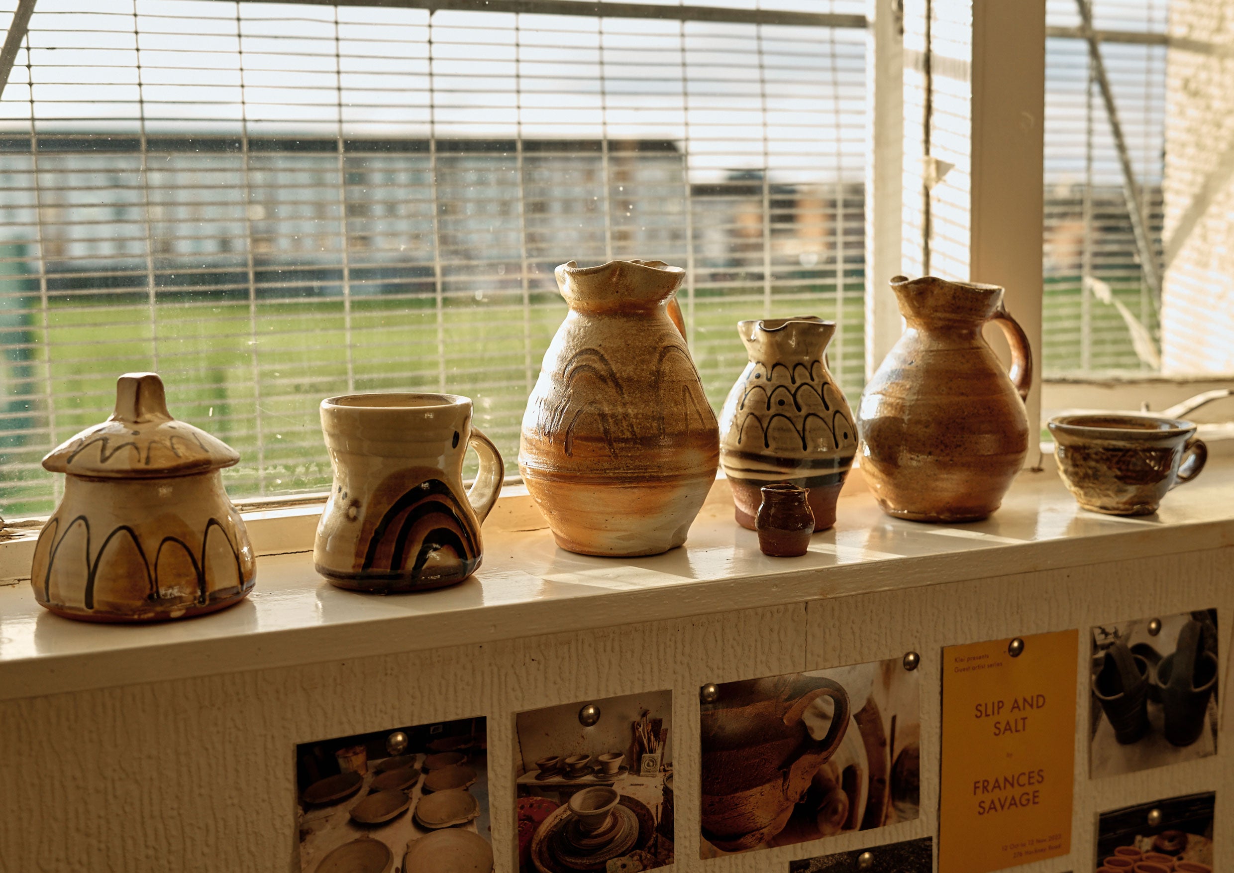 A line of pots on a shelf.