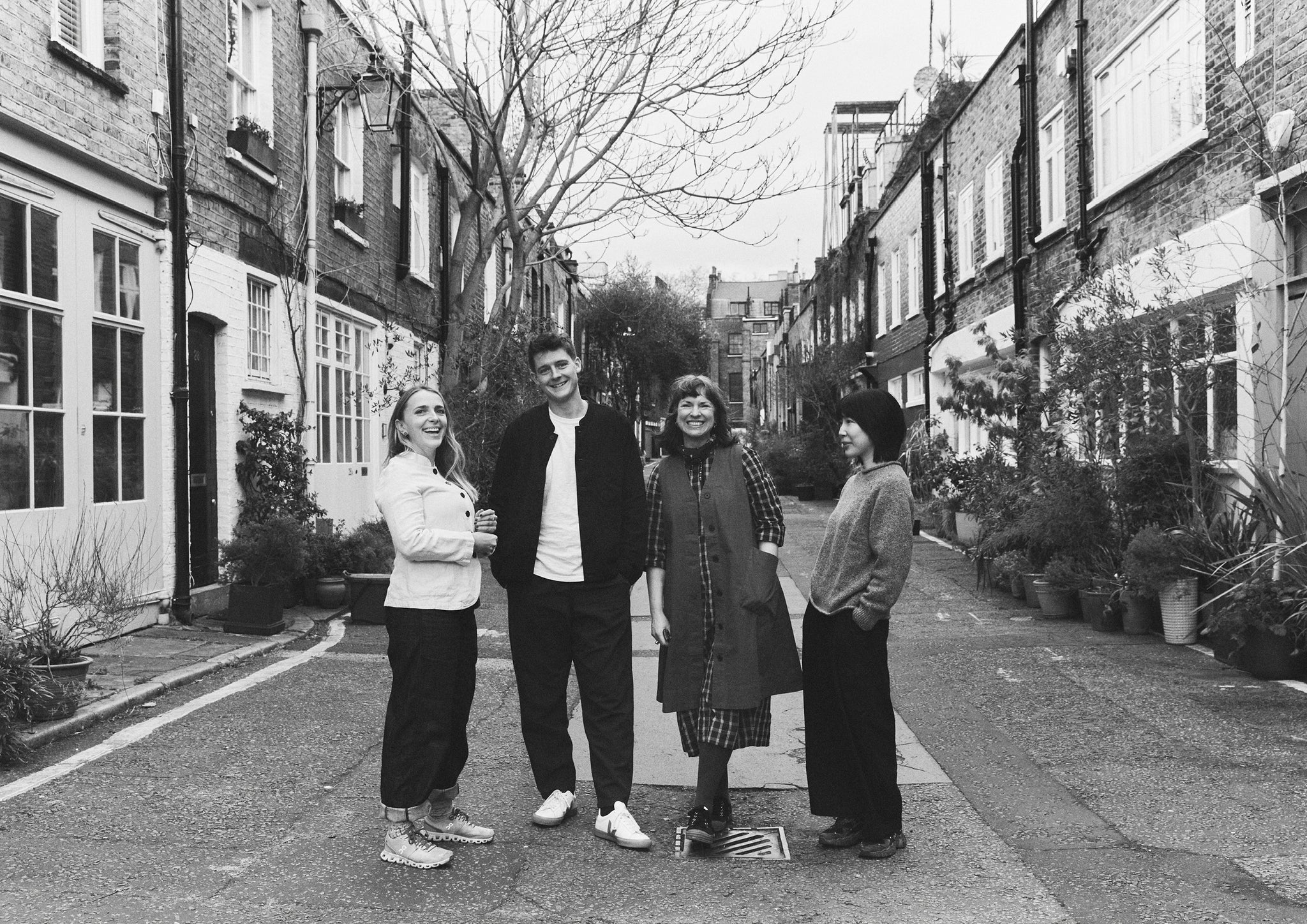 Black and white image of a group of people stood in the street