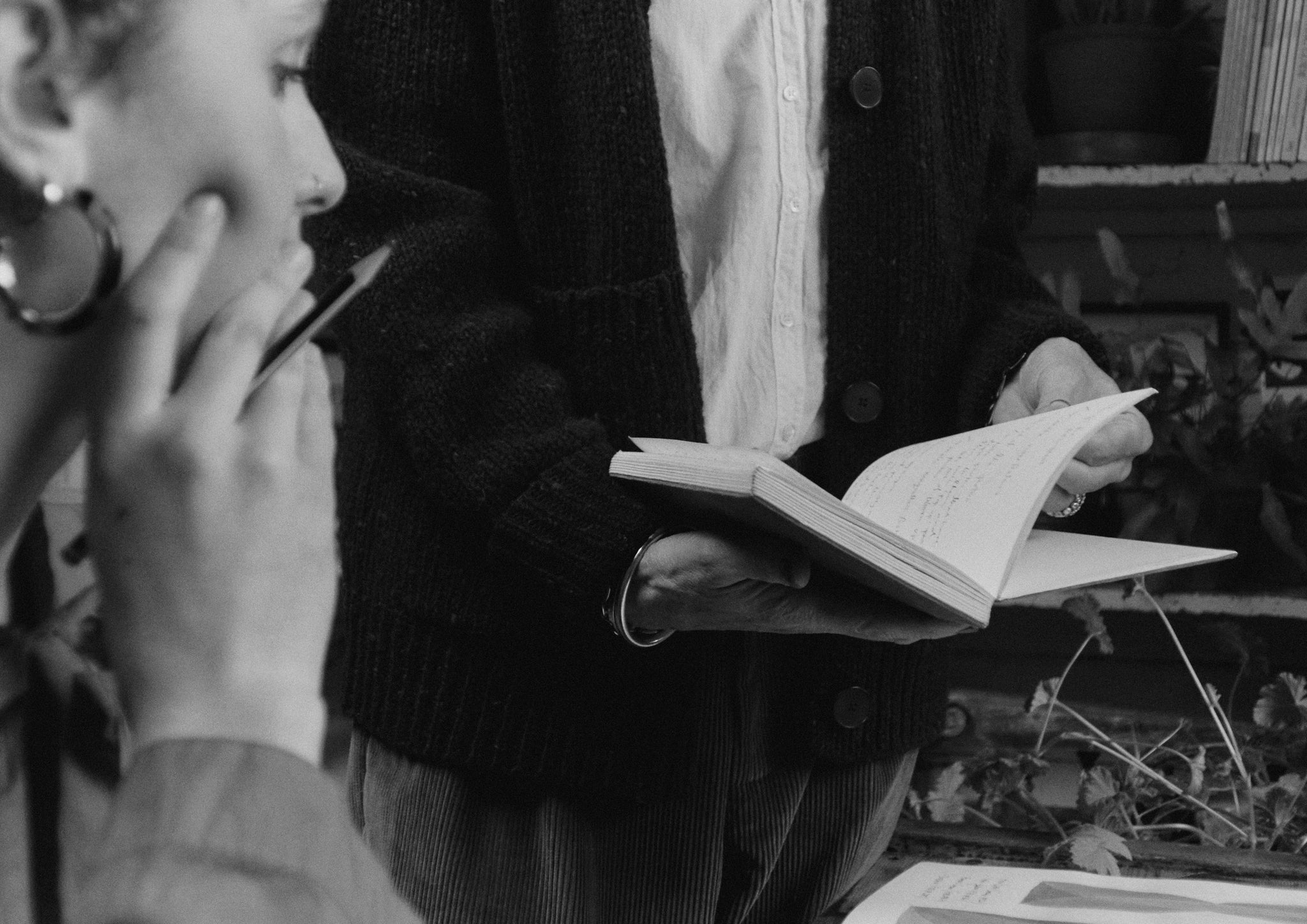 Black and white photograph of two women studying a book.