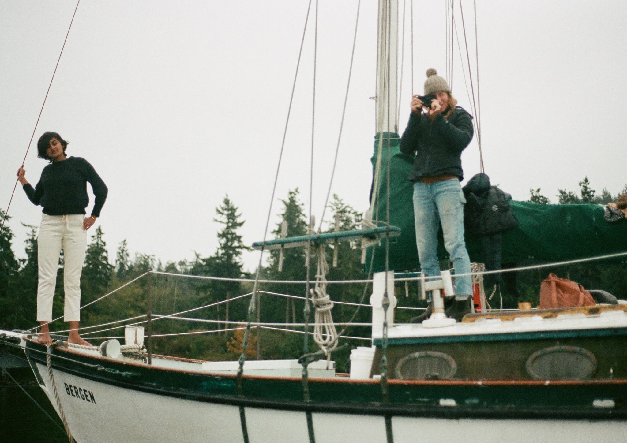 Two people stood on a sailboat