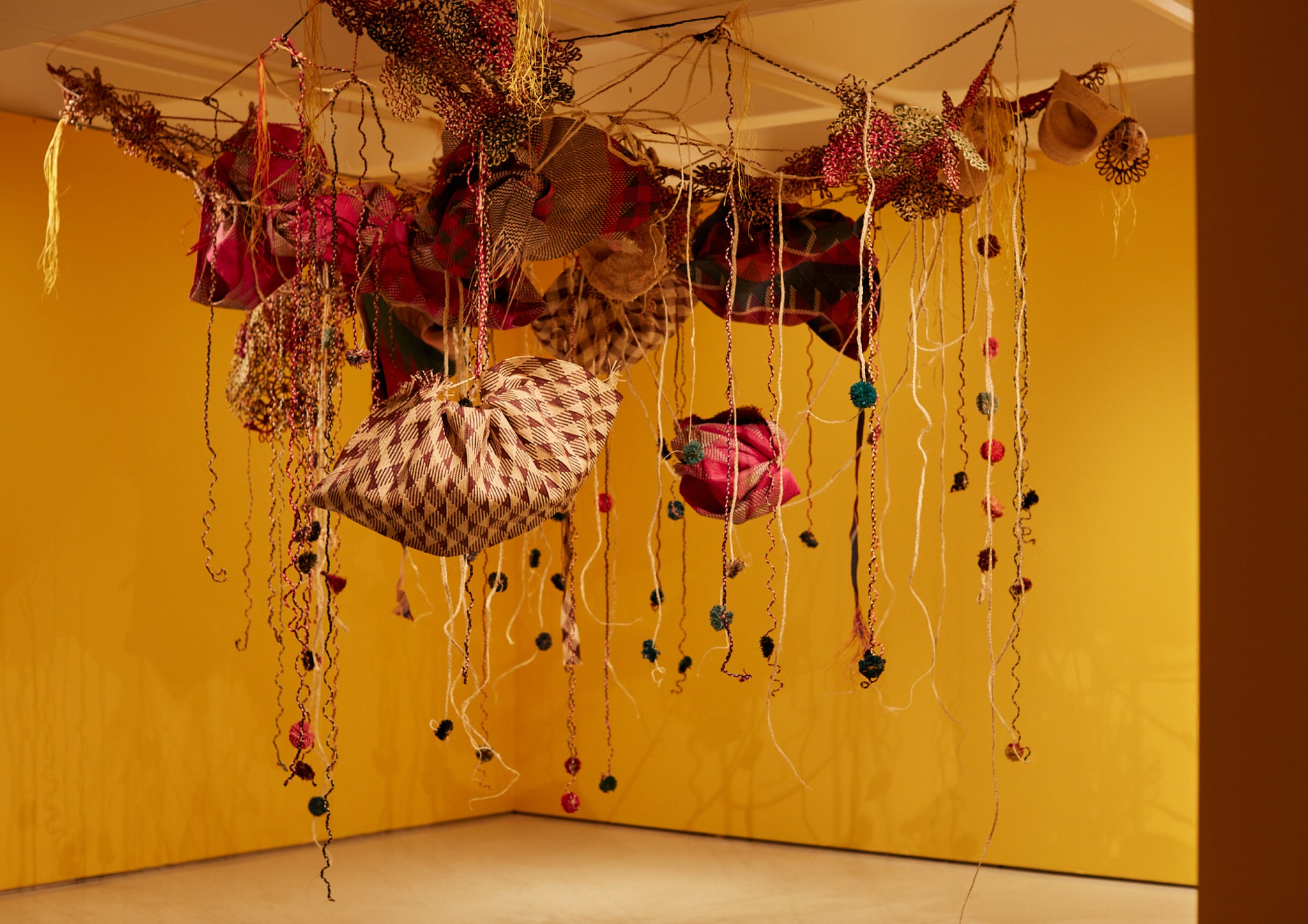 Textile installation hanging from the ceiling in an art gallery.