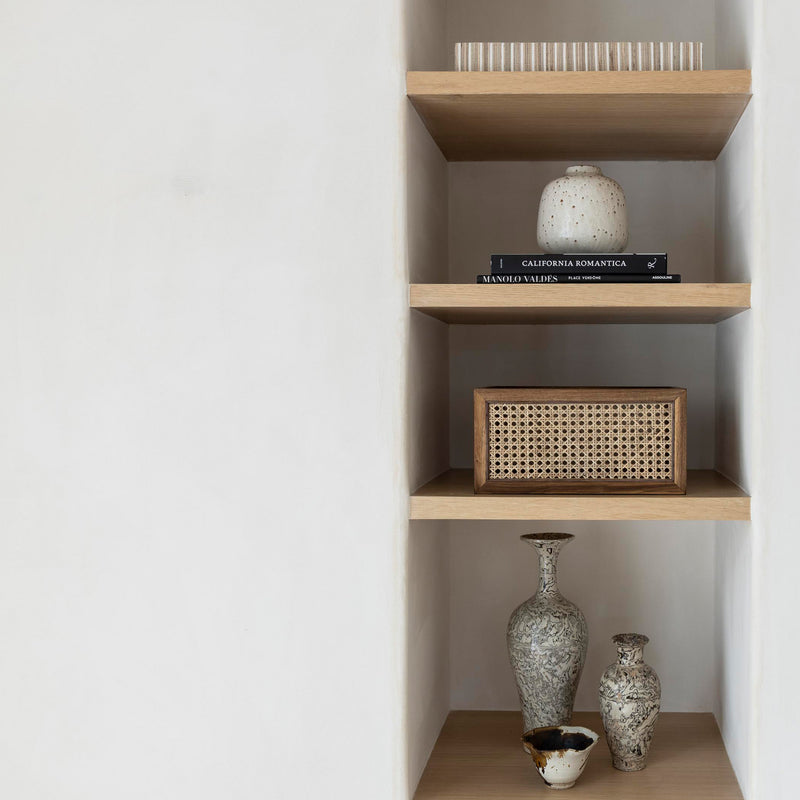 Rattan paneled organizing basket on open shelving