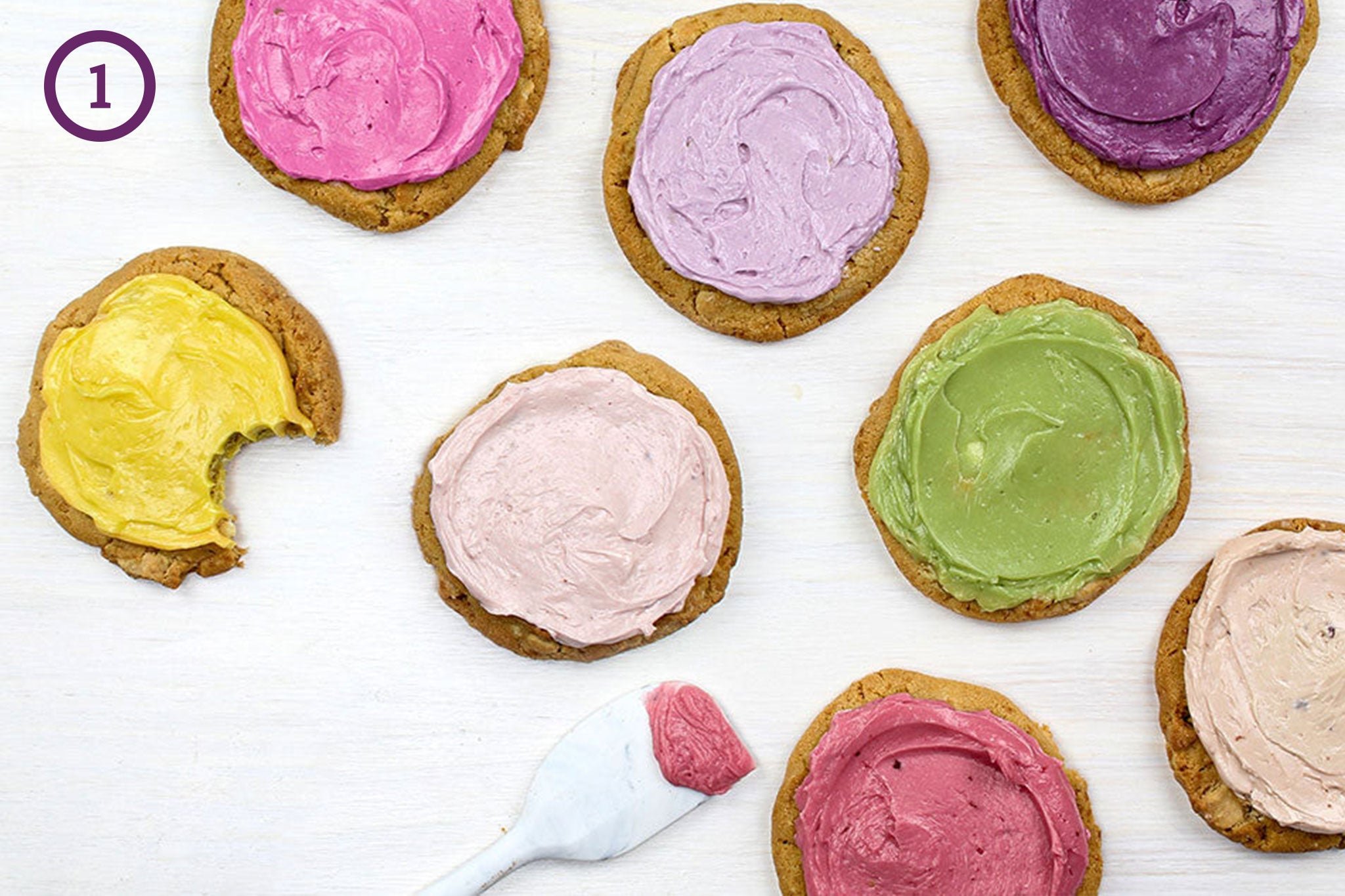 Cookies frosted with buttercream flavored with flavor pastes. The image is labeled "1" in the upper left corner. 