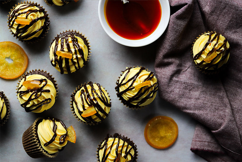 Image of Chocolate Cupcakes with Fond Royal Mousse, dark chocolate ganache drizzle and candied orange slices.