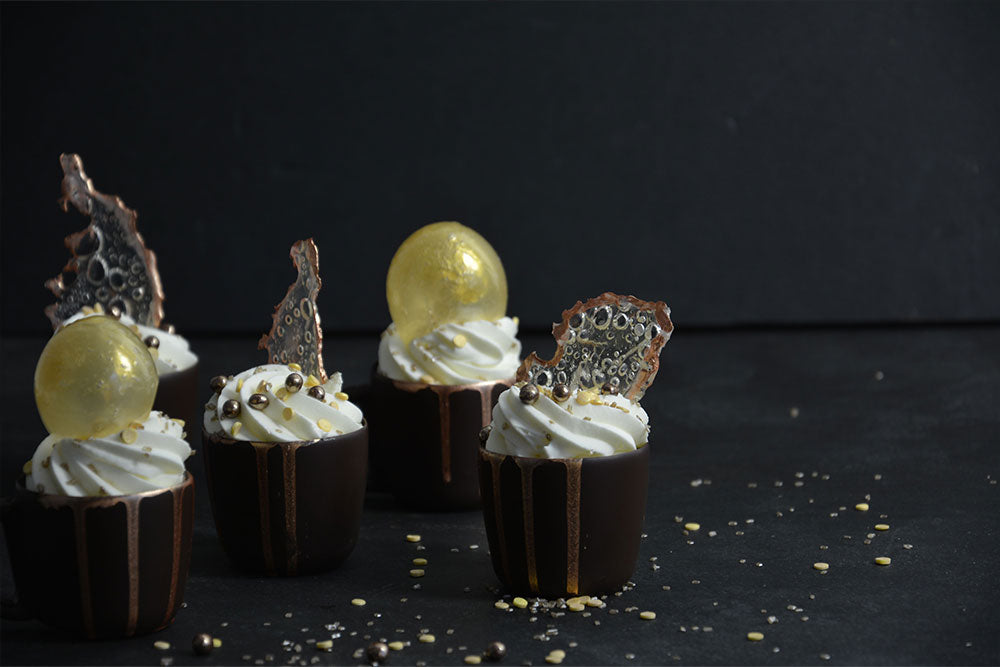 Mousse Filled Chocolate Cups with caramelized sugar decor against a black backdrop.  