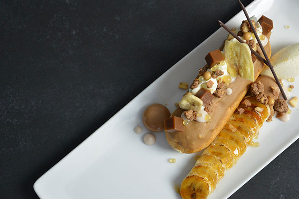 An eclair with caramel ganache, decorated with caramels, dried bananas, and caramelized bananas. 