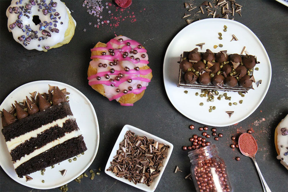 Multiple desserts decorated with PurColor sprinkles against a charcoal backdrop