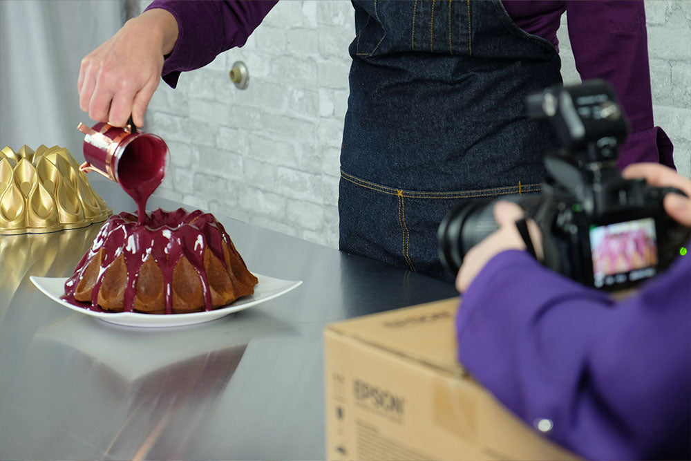 Behind-the-scenes photo of Chef Jessica Ellington preparing a cake for a photoshoot.