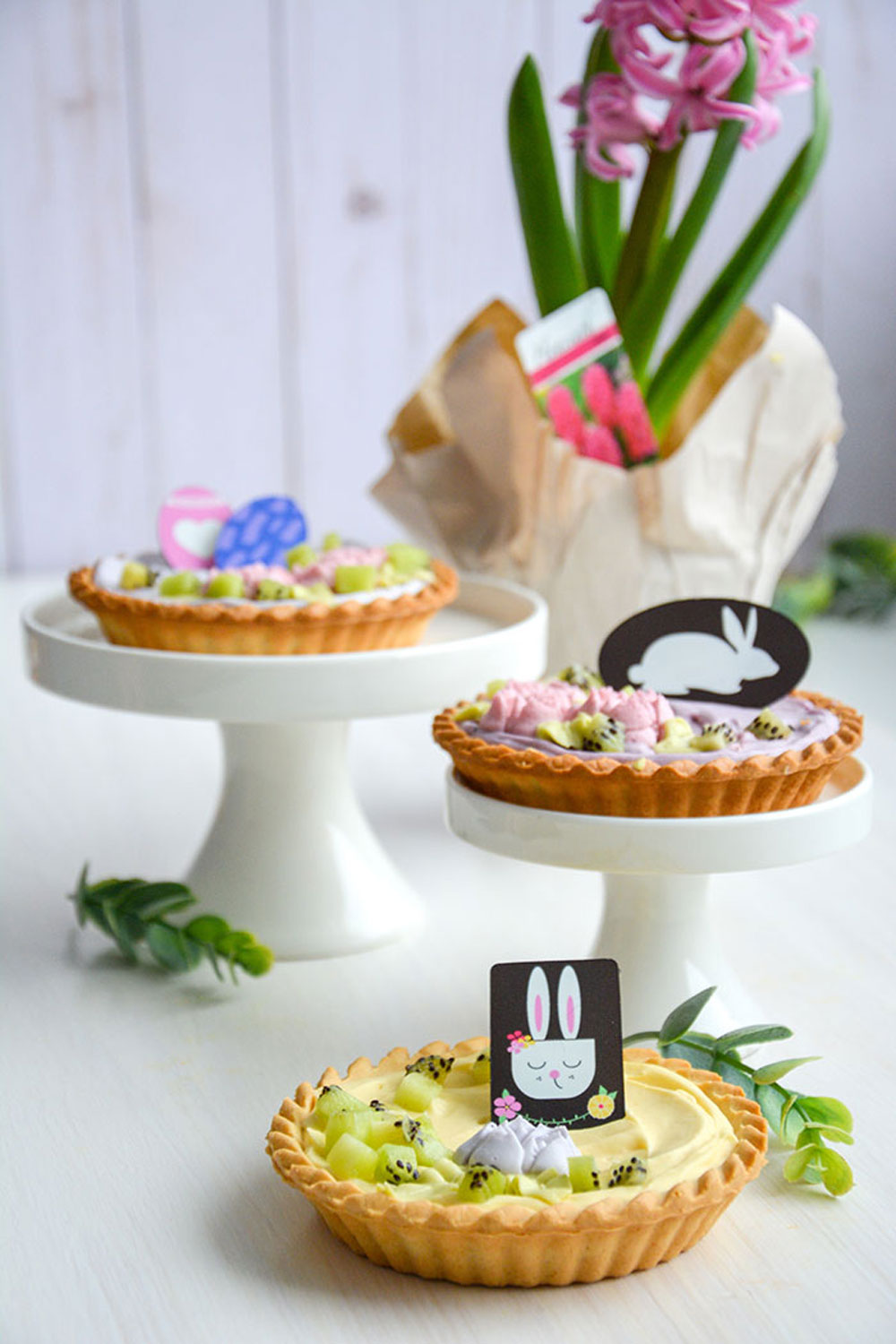 Butter tarts filled with multicolored pastry cream and chocolate easter bunny decorations on top