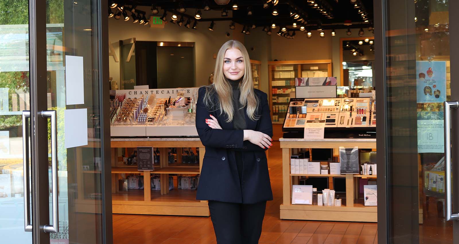 A Bluemercury beauty expert in front of a Bluemercury store