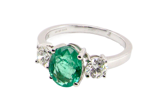 A fine emerald and diamond three stone ring