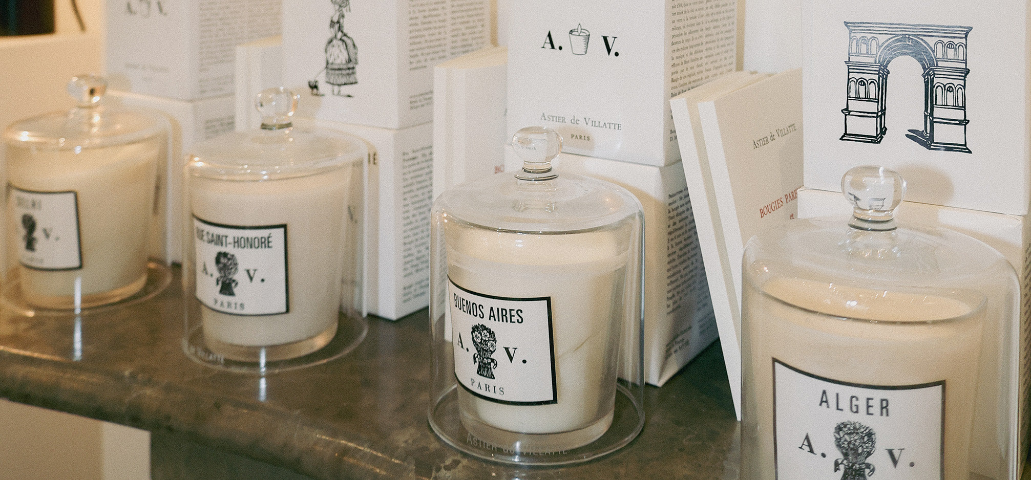 Astier De Villatte Candles in cloches on top of a fire place