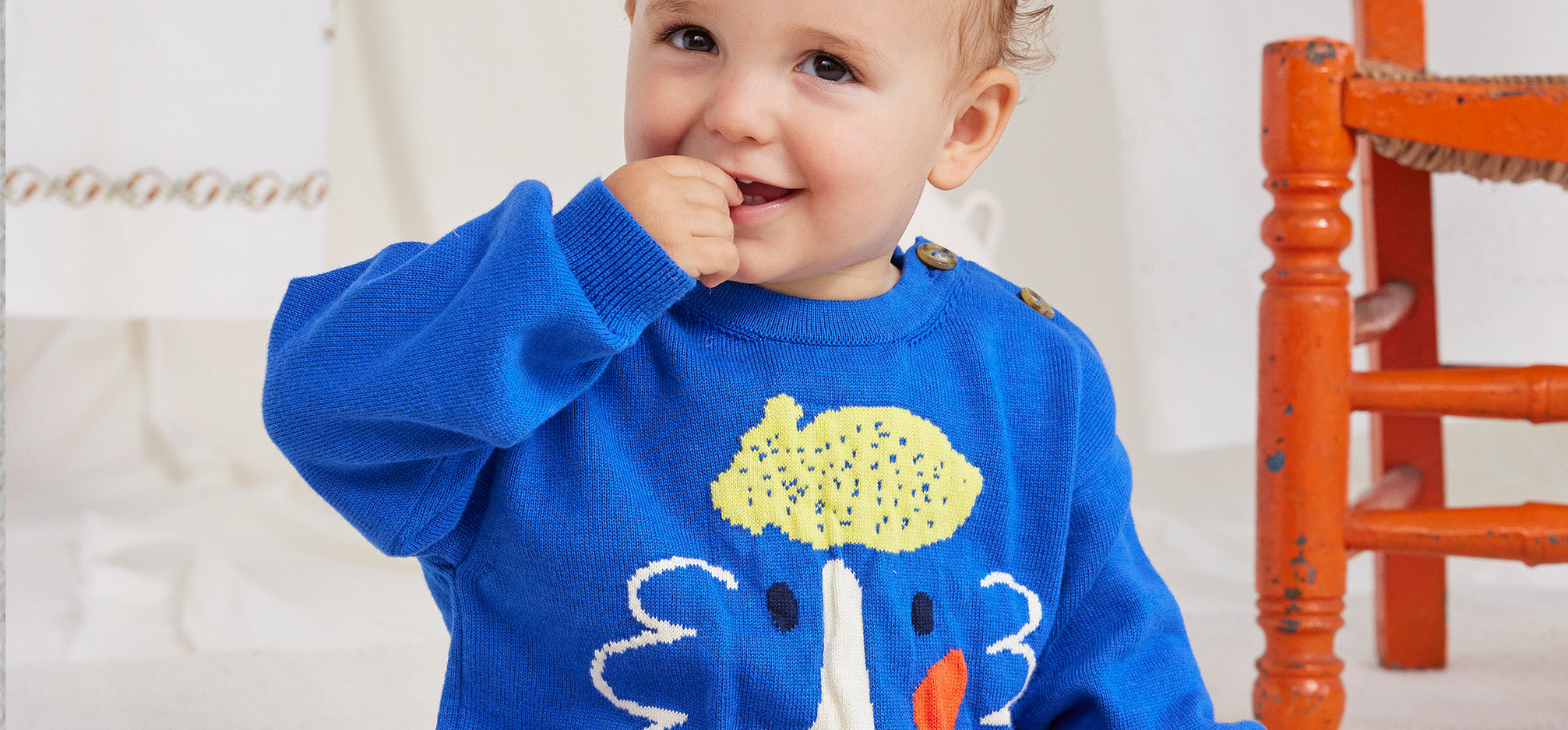 Baby wearing blue bobo choses happy face sweater
