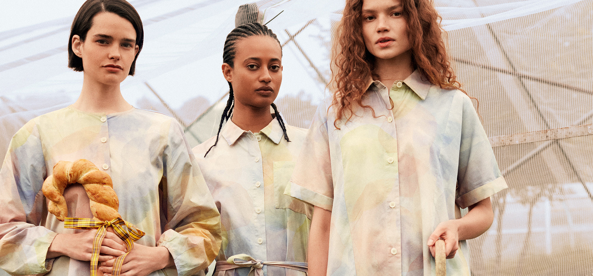 3 women wearing soft pastel rainbow print tops from Bobo Choses ss24. One is holding a breadstick