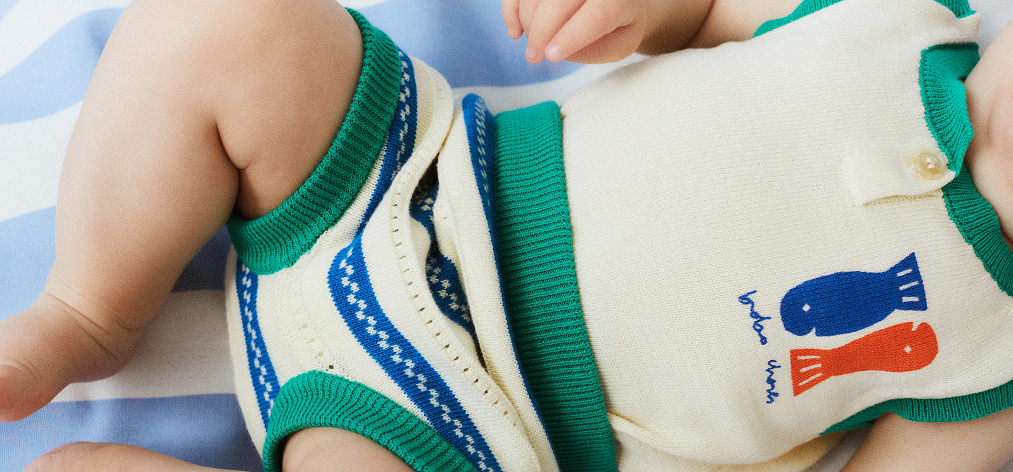 Baby wearing Bobo Choses white and green singlet and bloomers