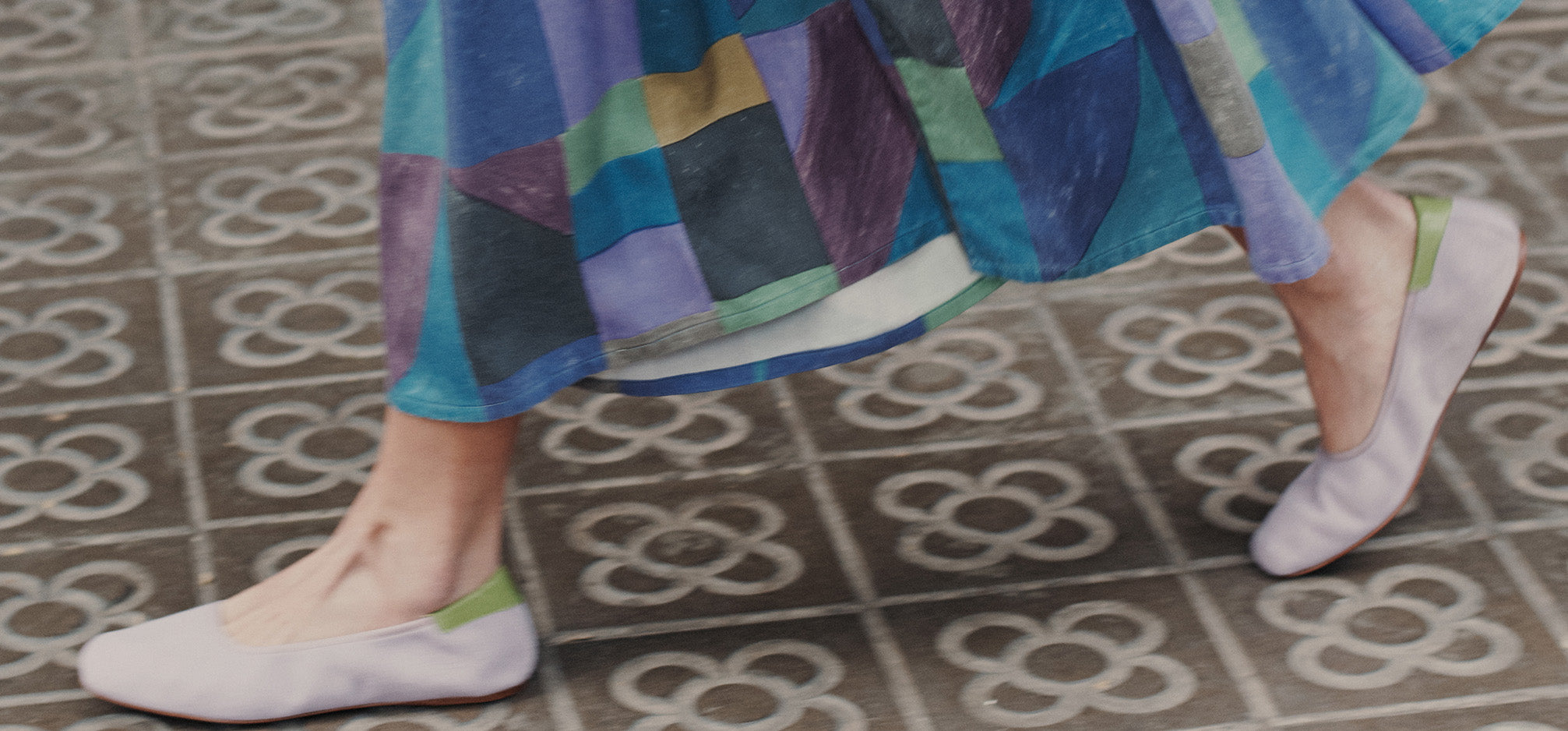 Woman wearing ballet flats walking on tiles