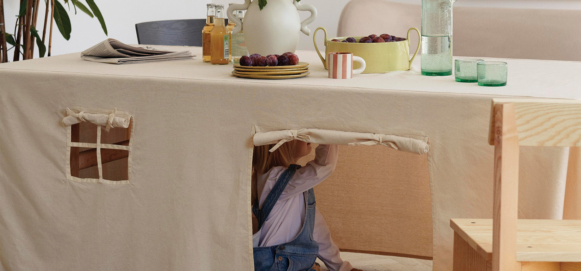 Child playing under table cloth tent