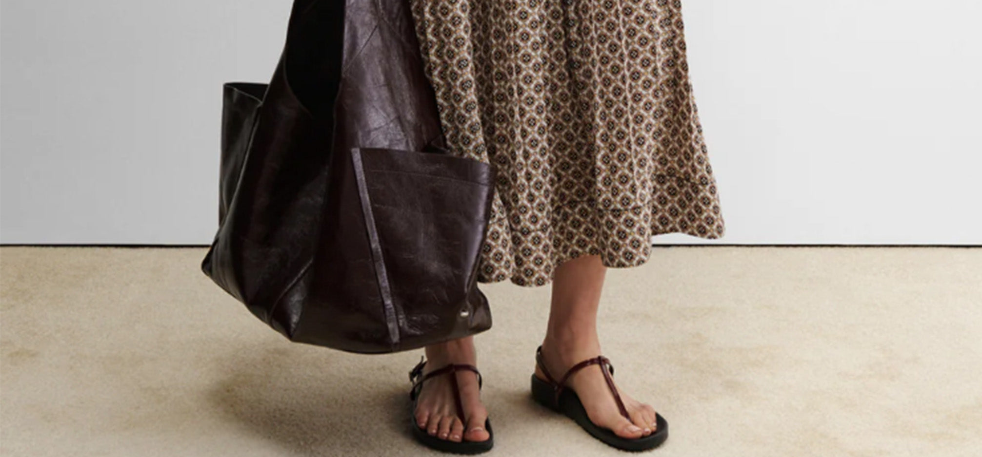 Woman wearing Rachel Comey dress wearing sandals and big burgundy handbag