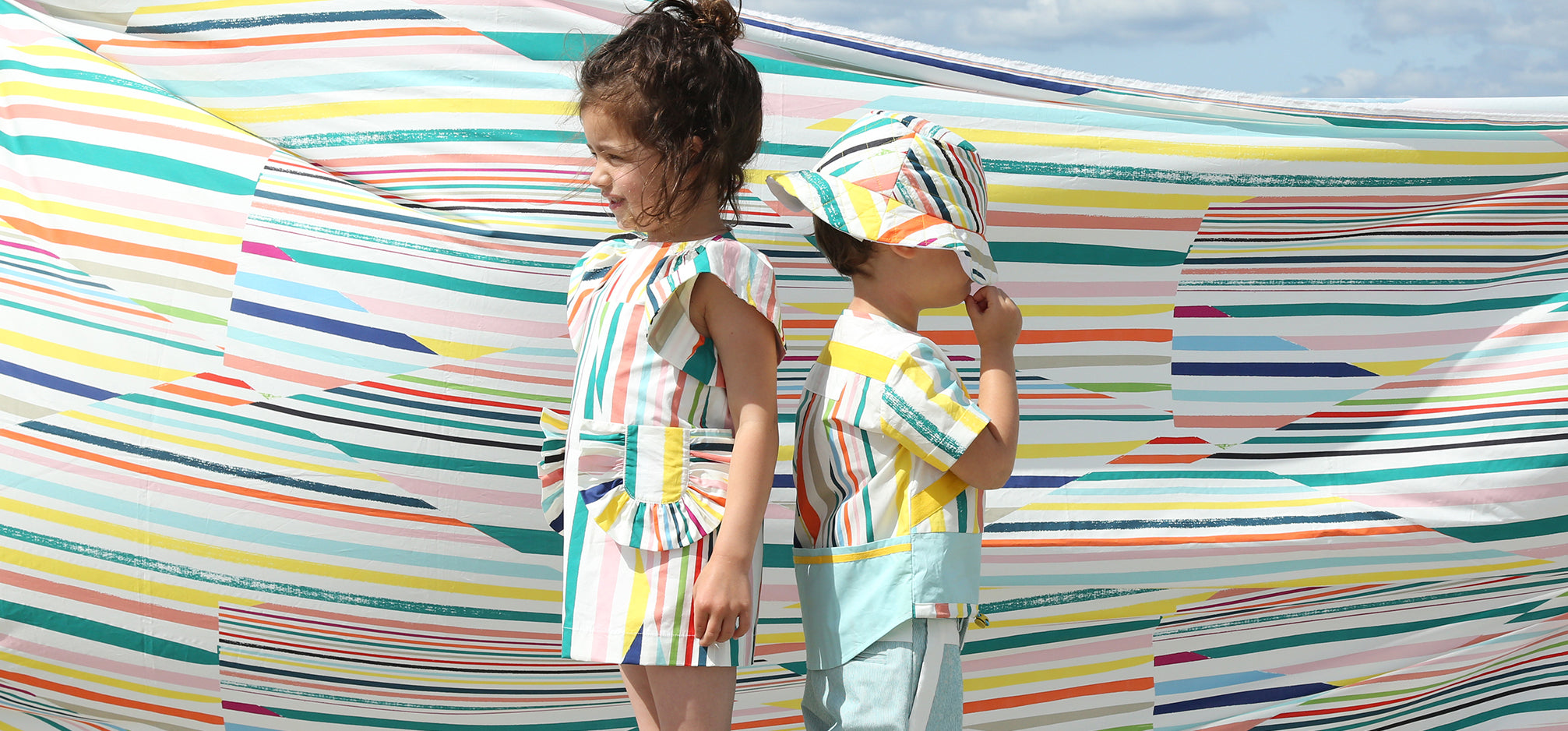 Two children in colourful striped outfits