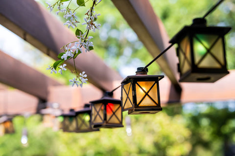 hanging lights up with S-Hooks underneath a pergola on a patio