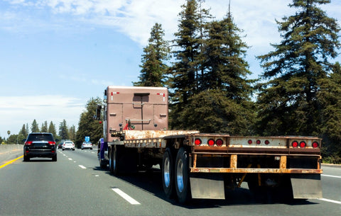 flatbed semi truck trailer driving down an interstate highway