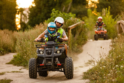 image of kids riding around on an off-road trail with an ATV