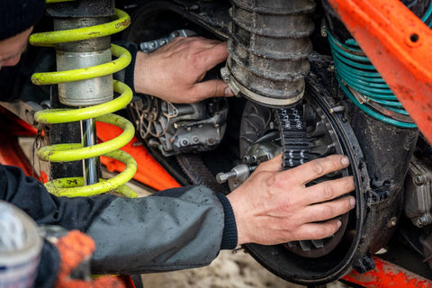 image of mechanic repairing atv with a replacement belt